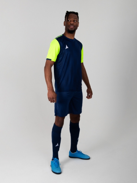 A model standing up wearing a Navy Football Training shirt, Navy Shorts and Navy Football Socks.