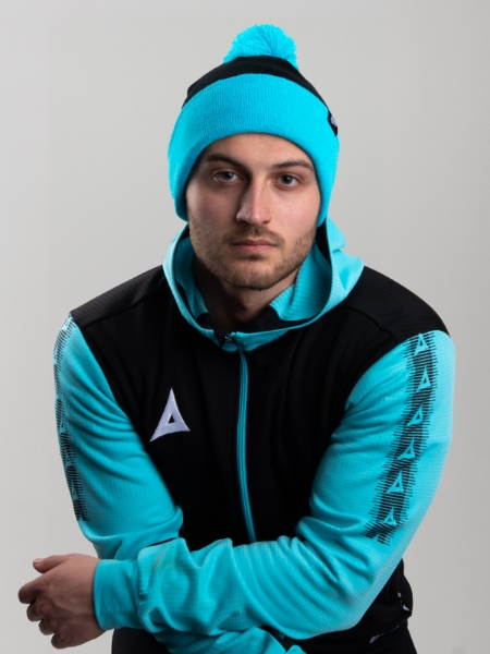 A man is wearing a Black and Blue Bobble Hat