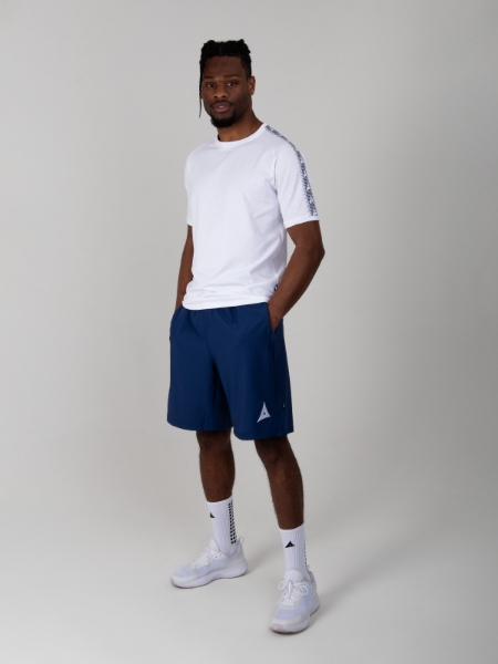 Model standing up wearing a plain white cotton t-shirt with Avec Logo taping print on sleeves, Navy Blue Coaching Shorts and White Grip Socks