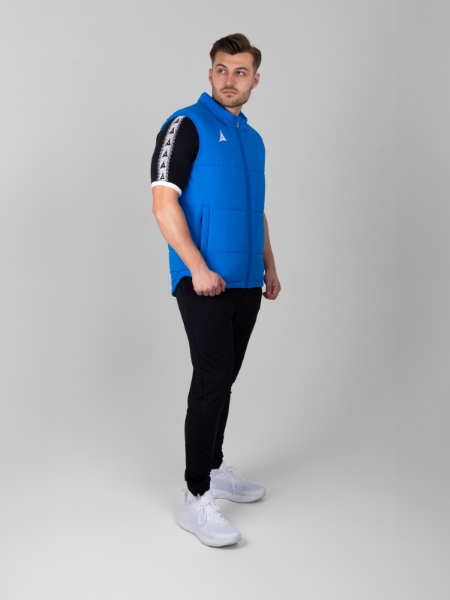 A man has a fully zipped Royal Blue Gilet on with a black t-shirt underneath.