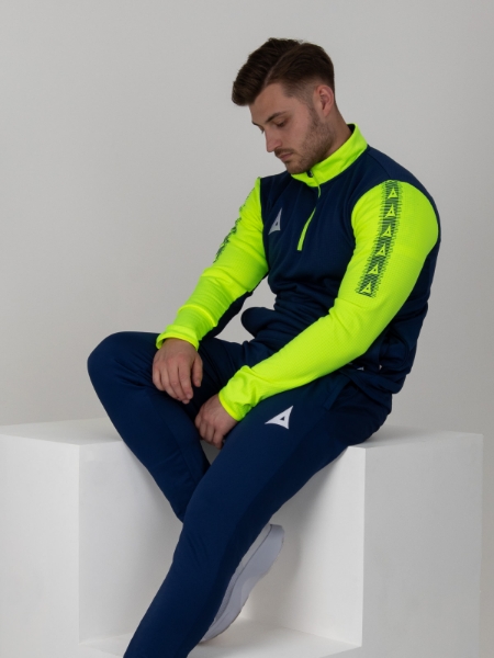 A man wearing a navy jumper with bright yellow sleeves and collar.