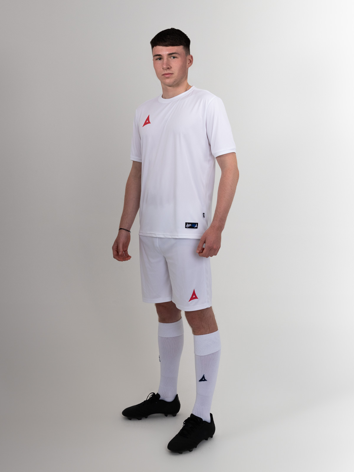 an all white football kit with red logos
