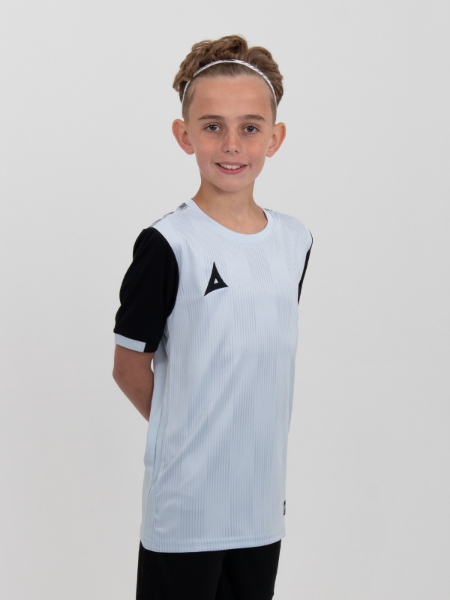A child is wearing a grey football shirt in a junior size.
