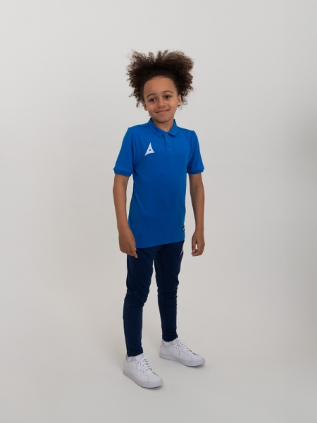A kid is wearing a blue polo short with navy jogging bottoms