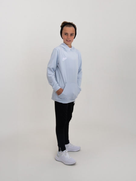 A kid is stood up wearing a light grey hoody and navy bottoms