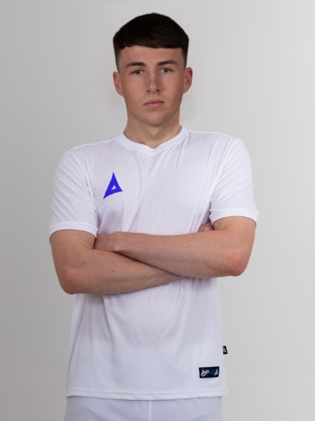 With his arms folded, this man is wearing a white football shirt with royal blue logo