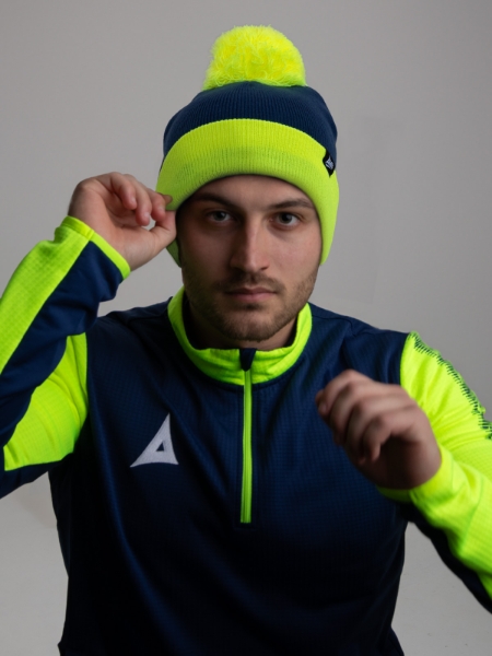 The person in this photo is wearing a navy and bright yellow hat to match his jumper