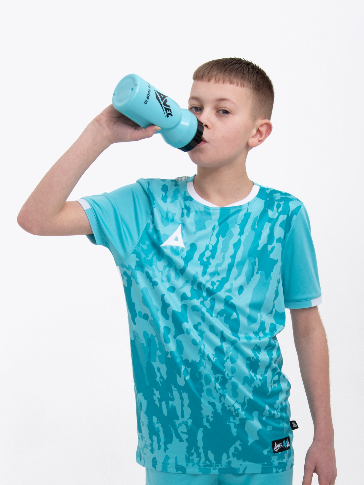 a kid is wearing a hyper blue football shirt and is drinking from a matching colour water bottle with a self sealing nozzle