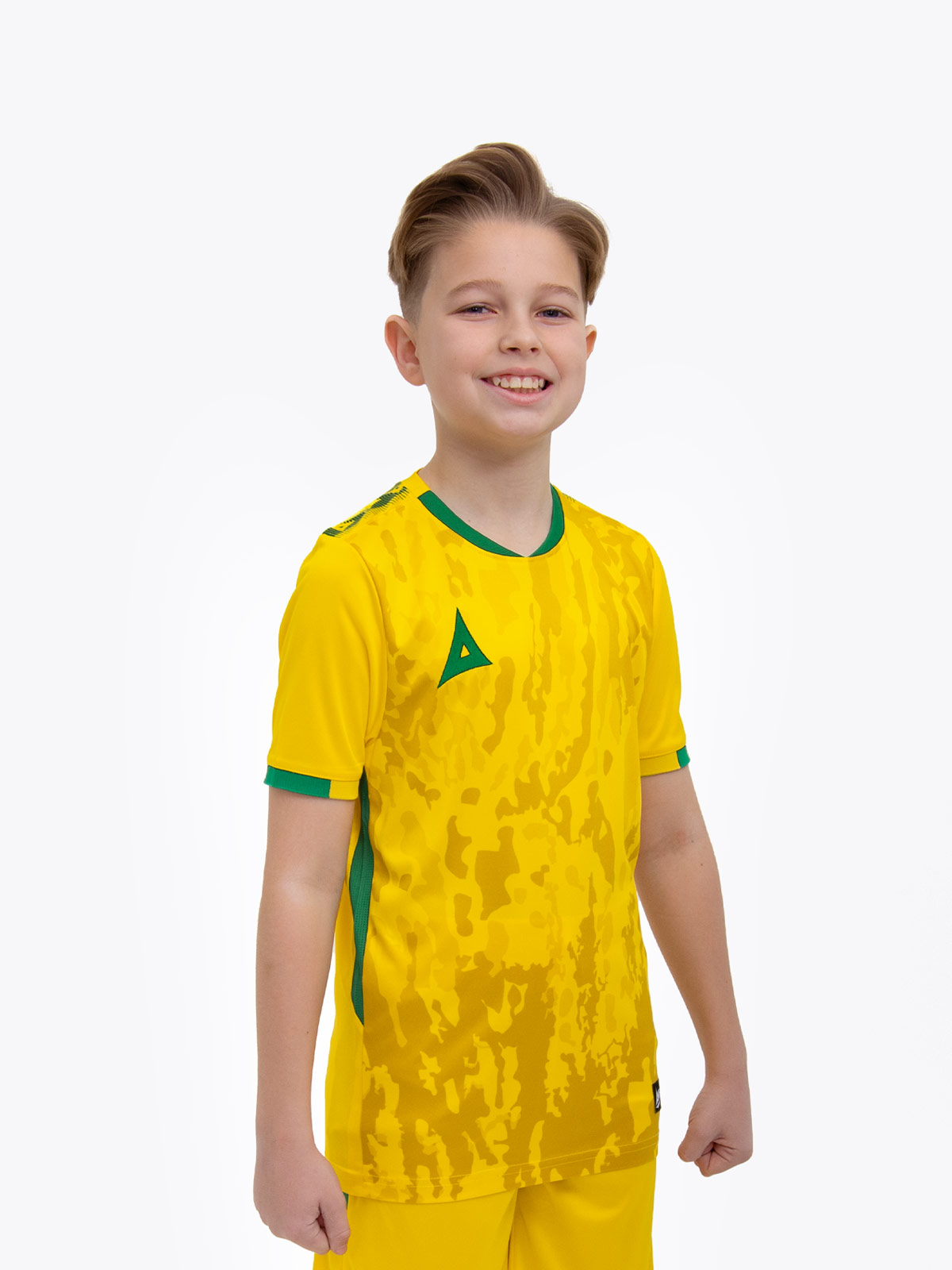 a young child is wearing a yellow football shirt. the football shirt has a camo pattern and green accent details
