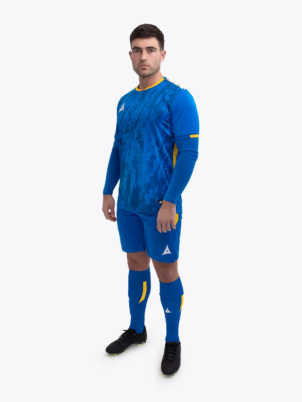 a model standing up wearing a royal blue football shirt, matching royal blue shorts and football socks.