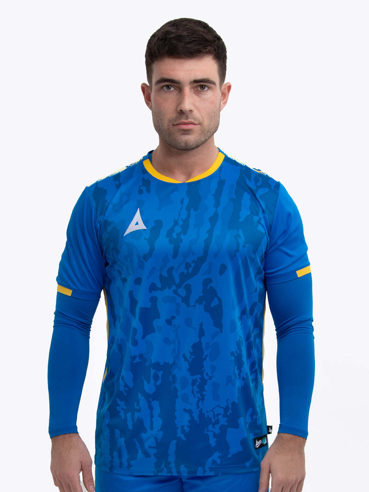a model standing up wearing a royal blue football shirt with a compression underlay in royal blue and yellow details