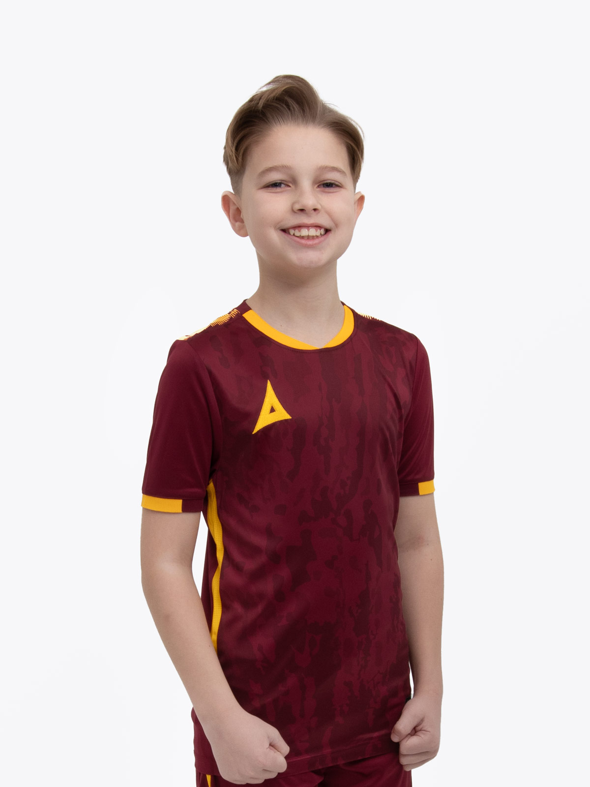 a young child is wearing a claret / maroon and amber football shirt. the football shirt has a camo pattern