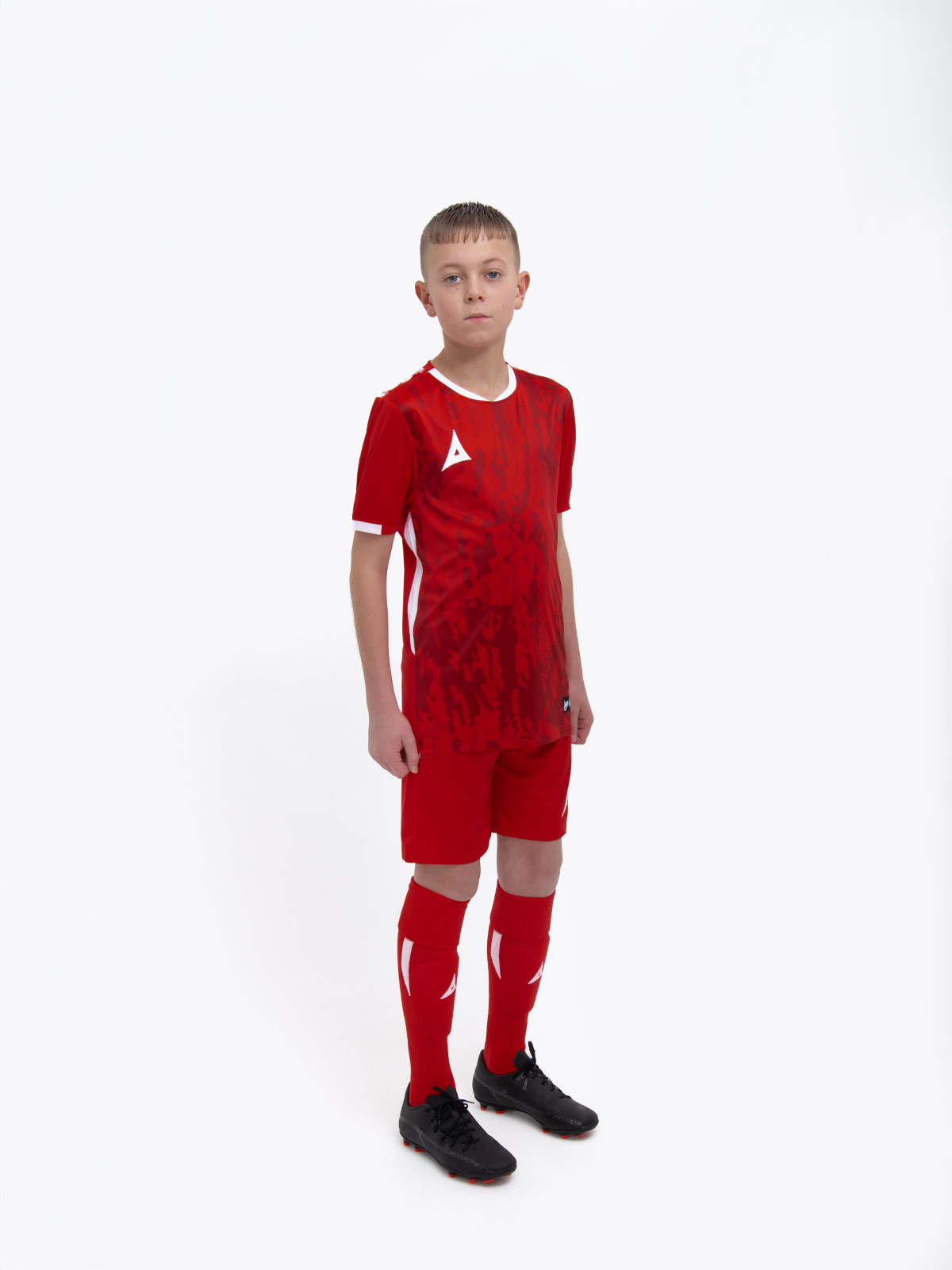 a kids football kit in red with matching red shorts and socks
