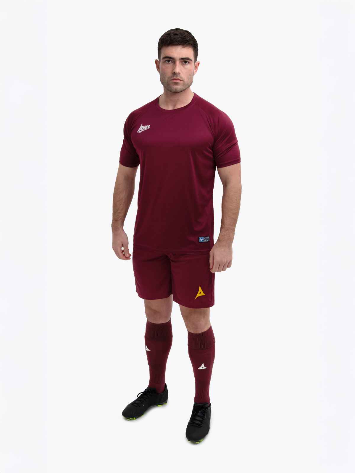 a man in a football kit which is claret / maroon with matching claret shorts and socks