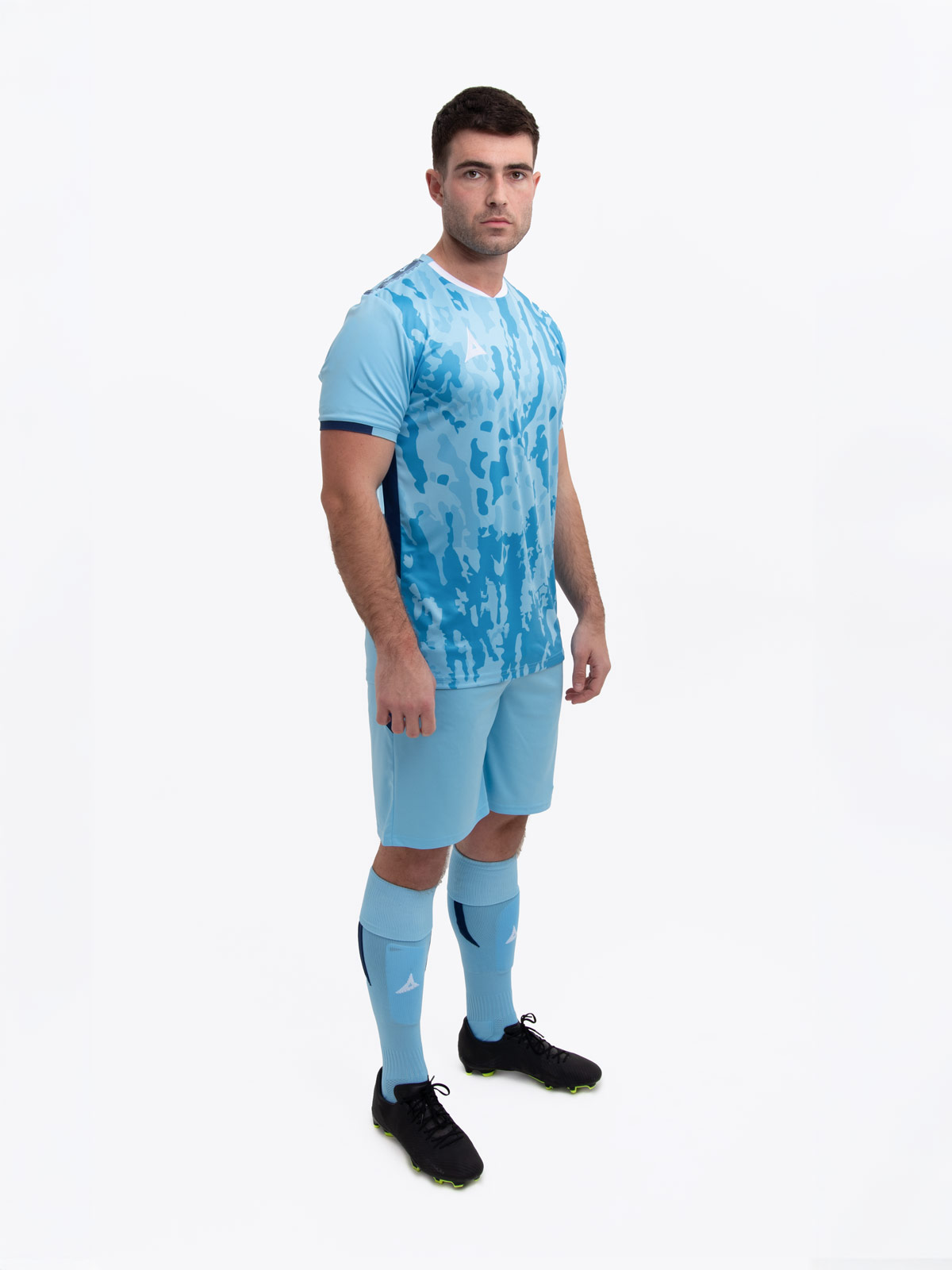 a model standing up wearing a sky and navy football shirt, sky shorts and sky football socks.