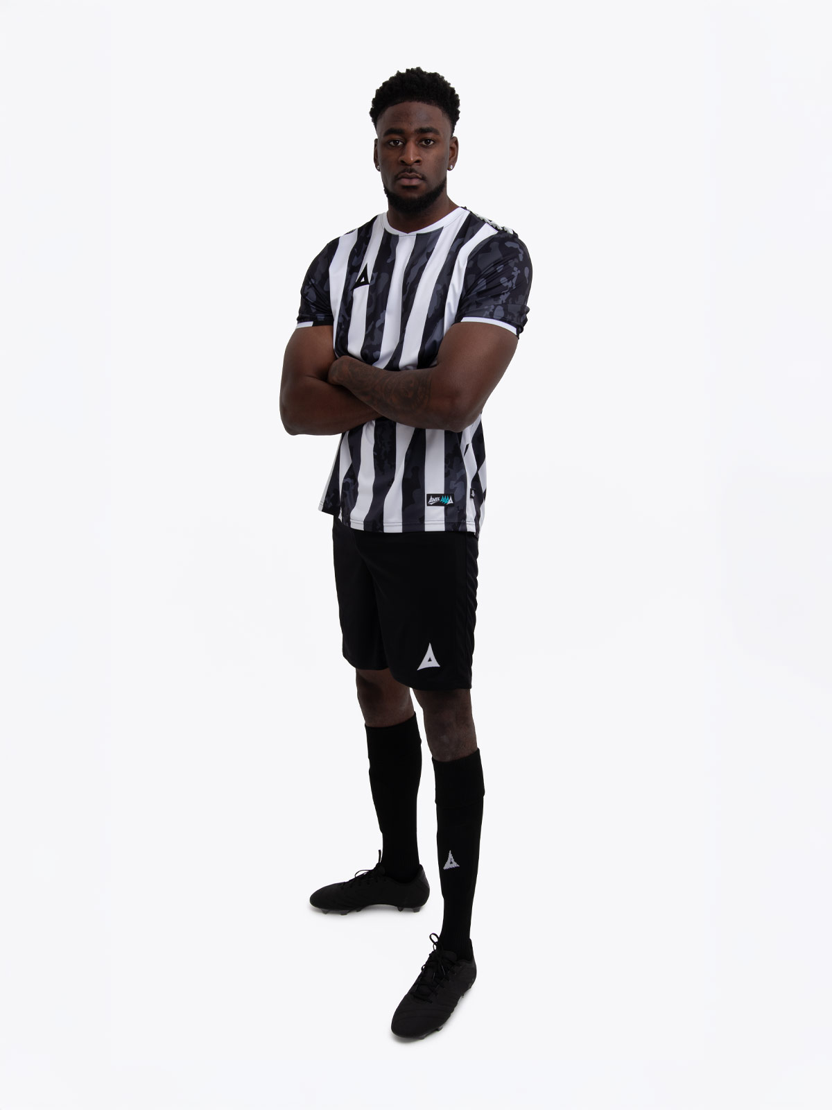 a man in a black and white stripe shirt, black shorts and socks.