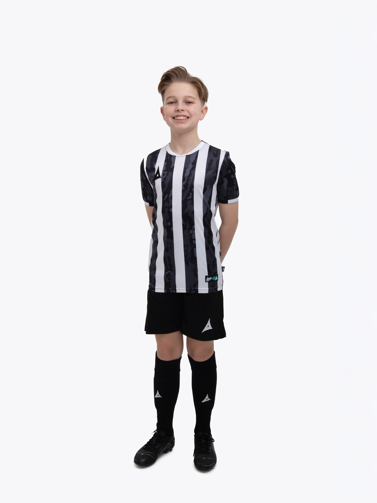 a young child in a black and white stripe shirt, black shorts and socks.