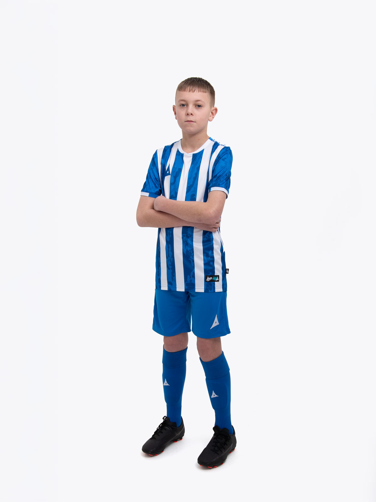 a kid is wearing a blue and white football shirt, and paired it with blue shorts and blue socks