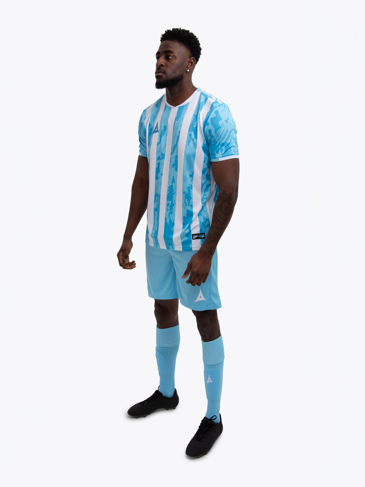 a man is wearing a sky blue and white shirt, alongside sky blue shorts and sky blue socks