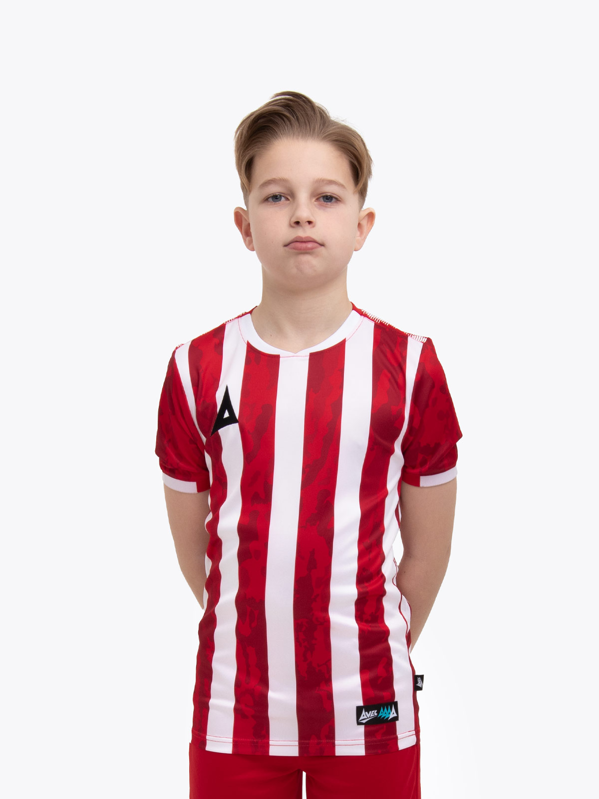 a young child is wearing a red and white striped football shirt. the football shirt has a camo pattern