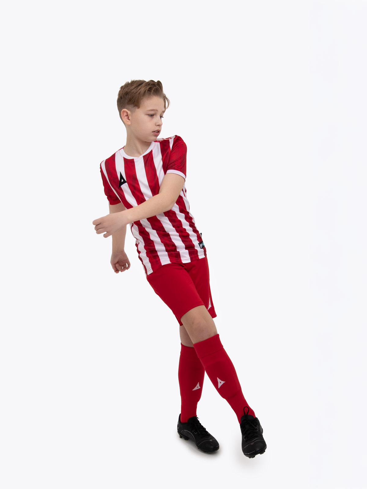 a kids football kit in red and white with stripes and matching red shorts and socks