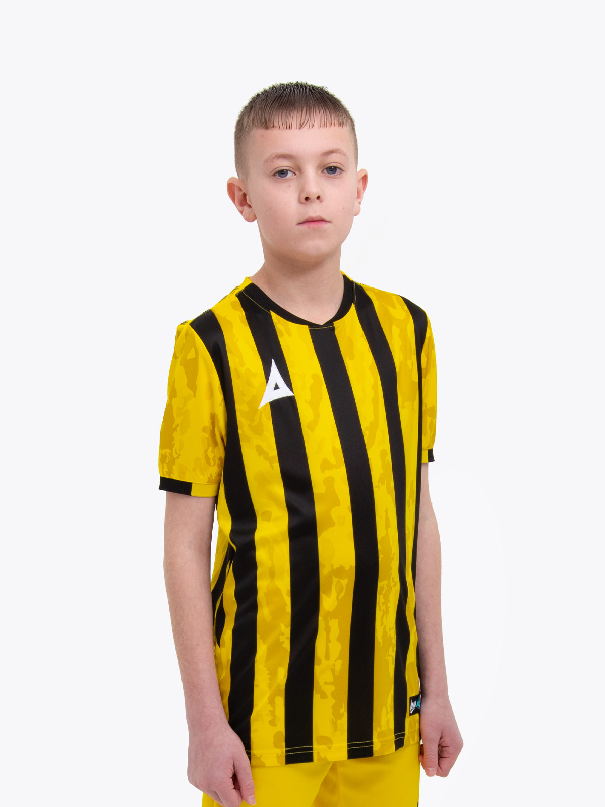 a kids football kit in yellow and black with stripes and a camo pattern