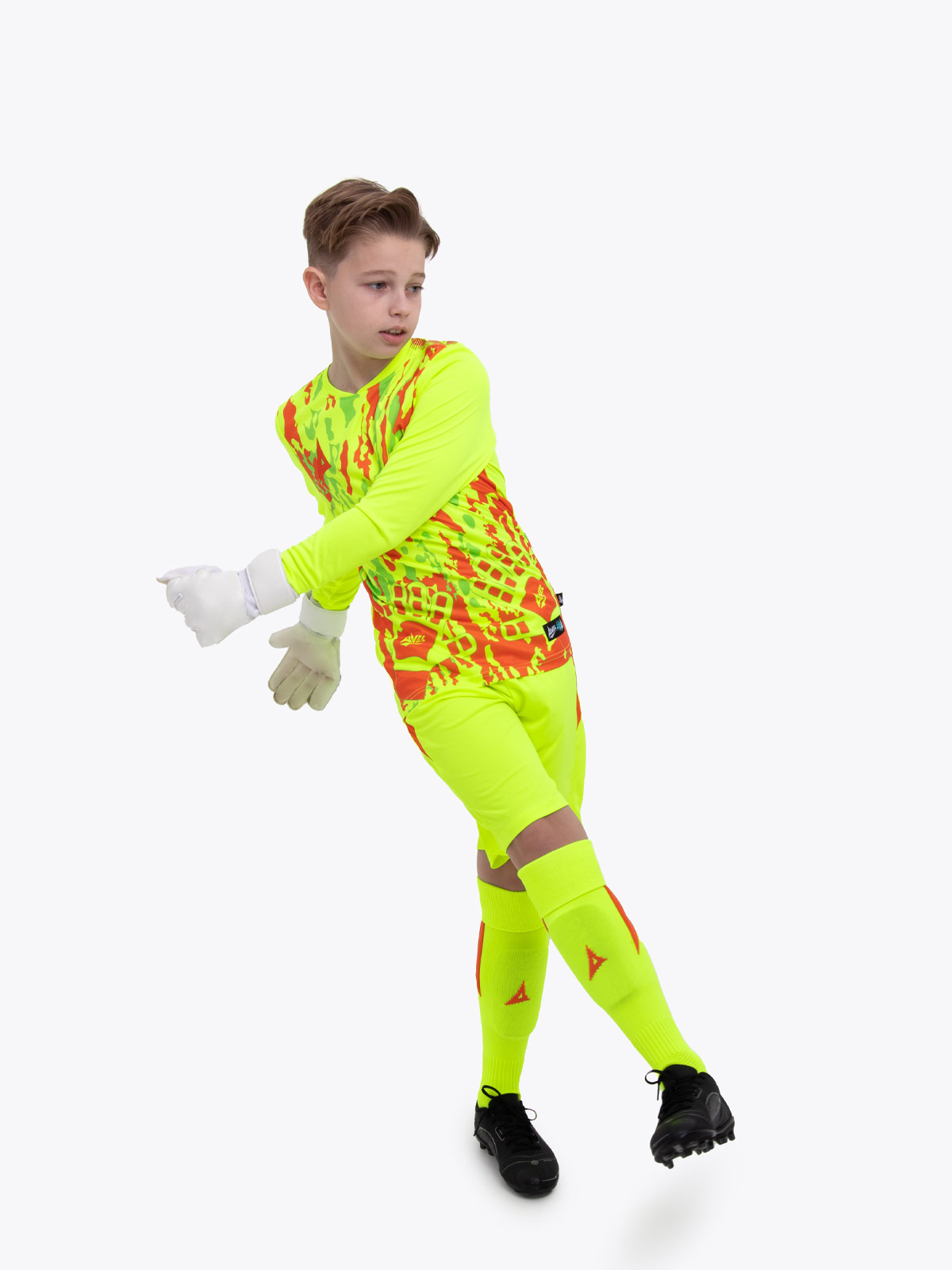 a young boy is wearing a full neon yellow goalkeeper football kit with an orange trim and detailing