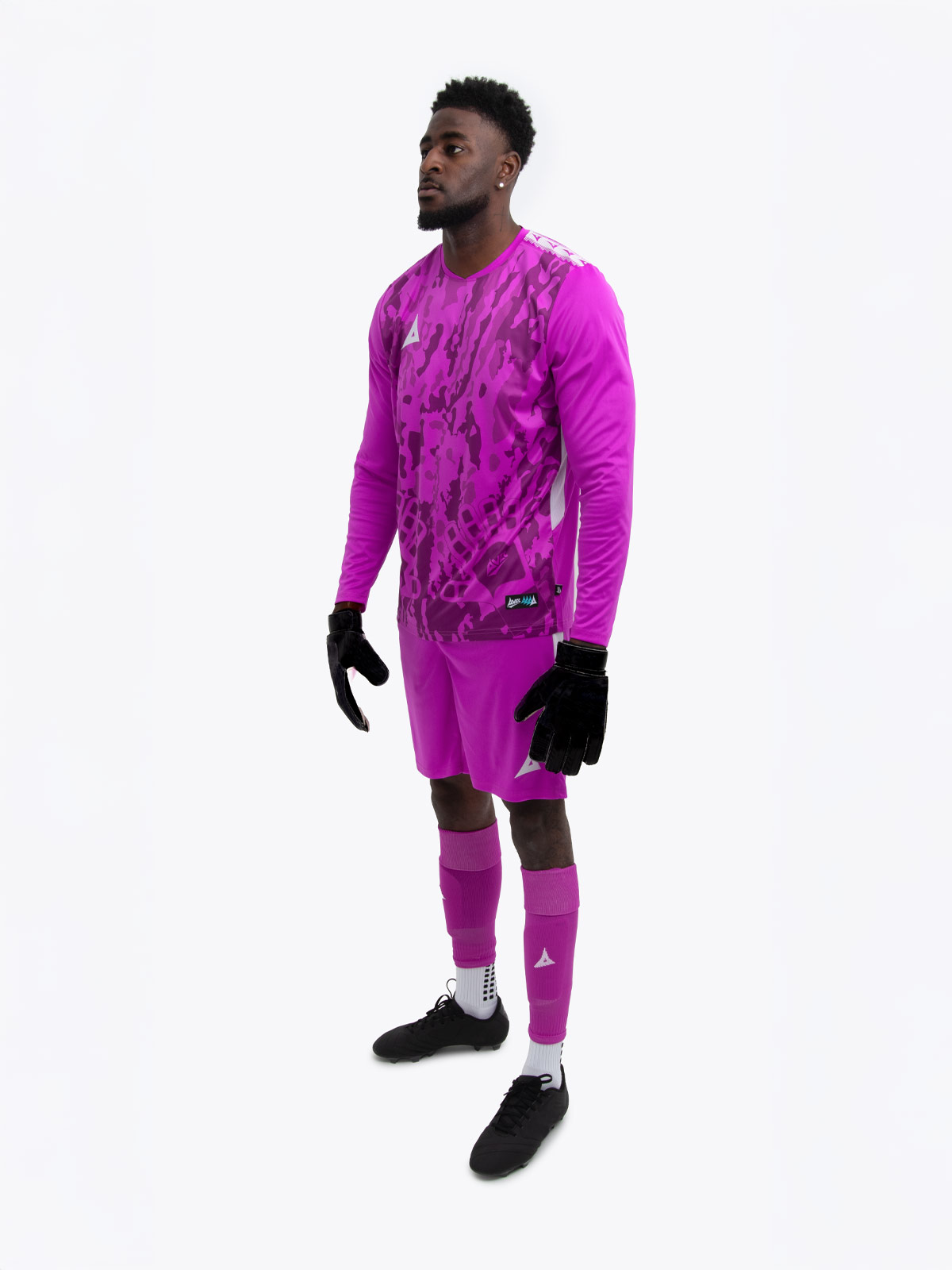a model is wearing a full magenta goalkeeper football kit