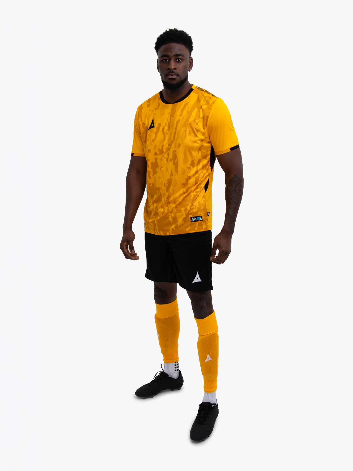 a model is wearing an amber football shirt with black detailing