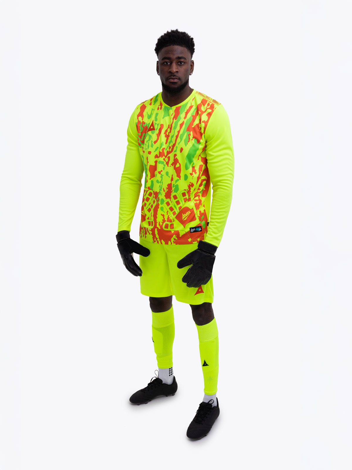 a model is wearing a full neon yellow goalkeeper football kit and holding a neon yellow football matching the kit