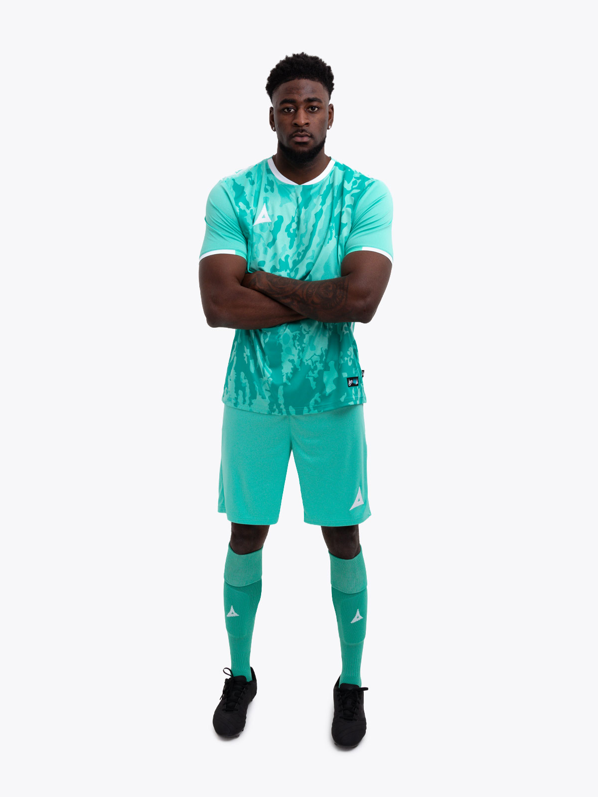a model standing up wearing a mint green / hyper green football shirt, matching shorts and matching football socks.